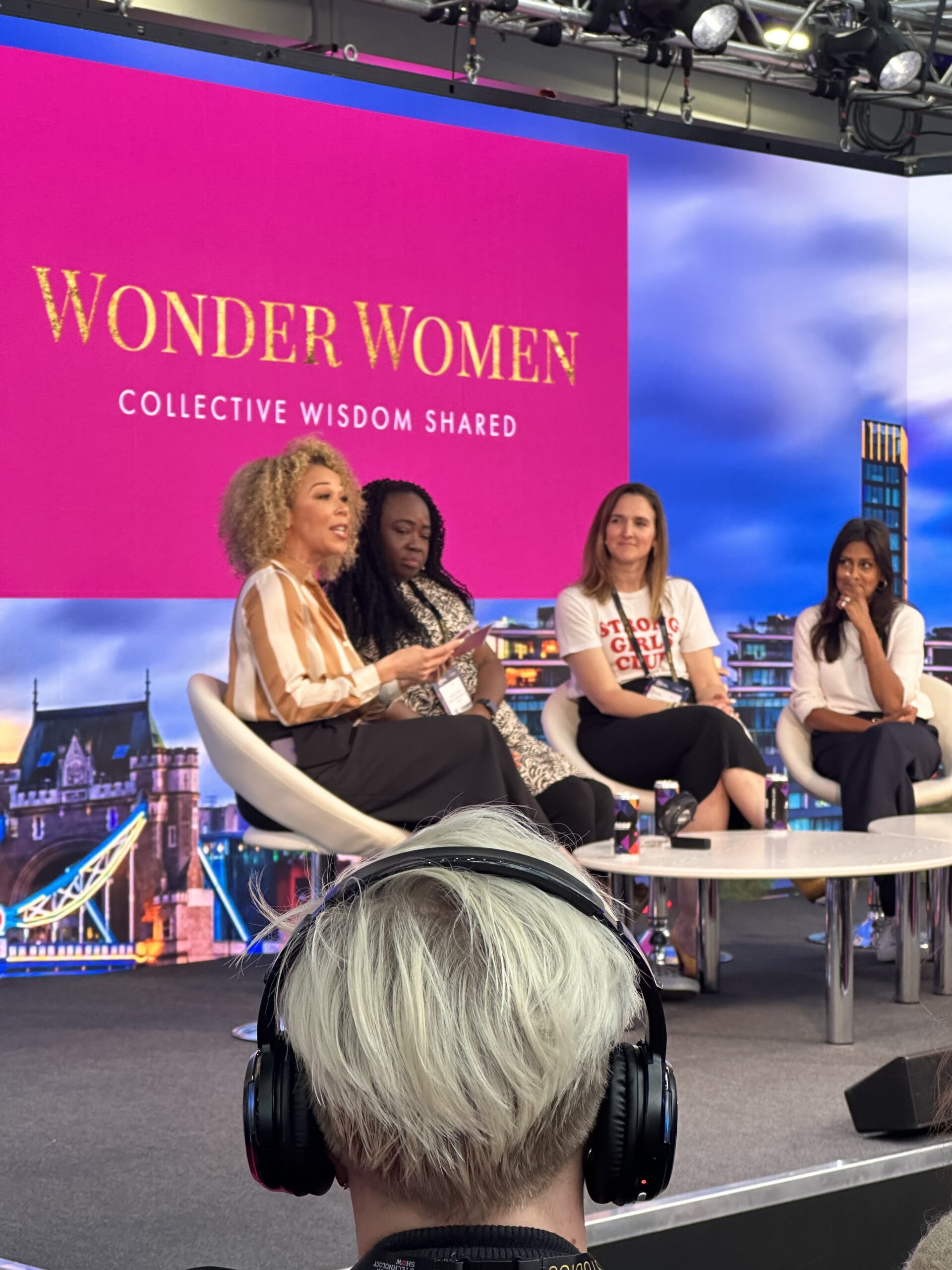 4 women sit on a panel at the front of the room